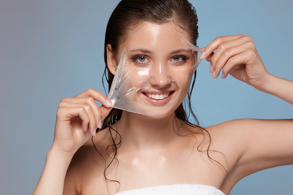 a woman holding a clear mask over her face